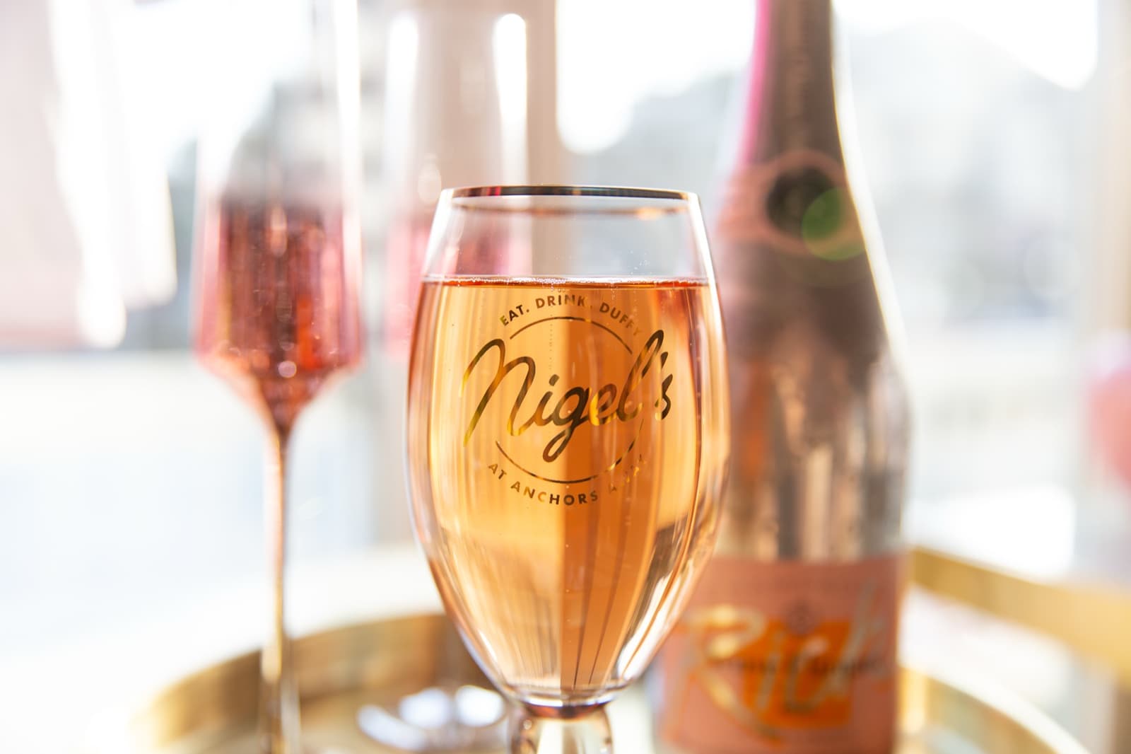 Rosé blushing in a Nigel's flute at golden hour