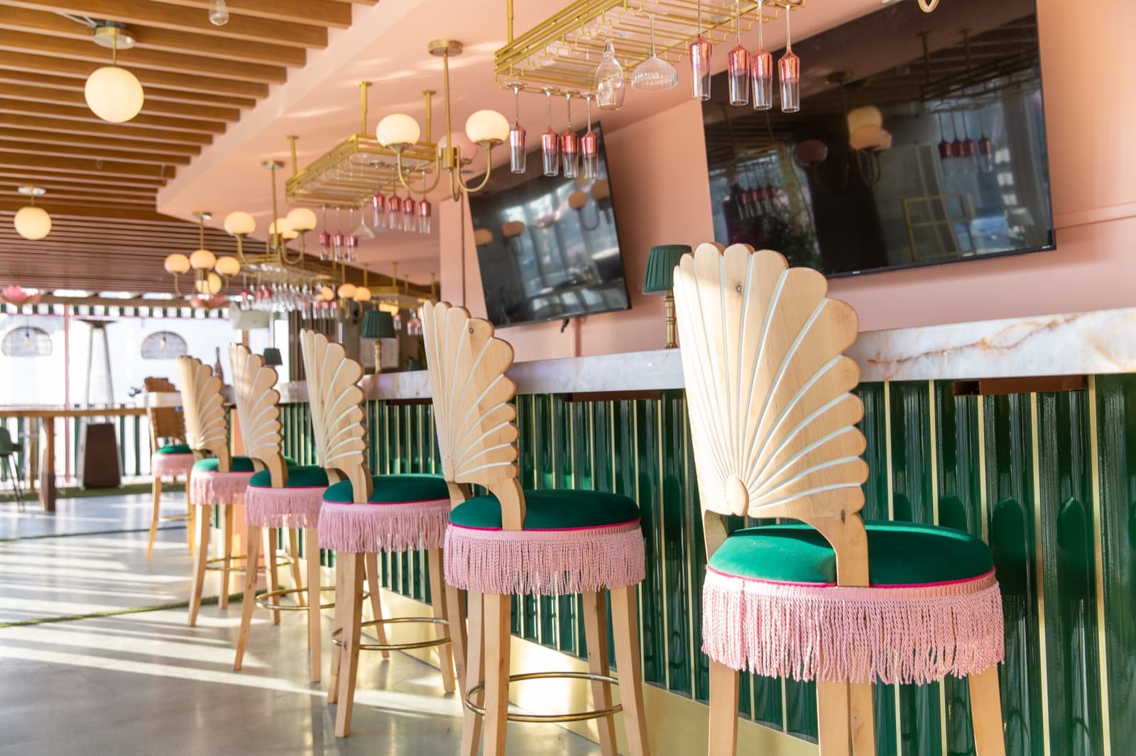 Fan-back stools line the jewel-green champagne bar