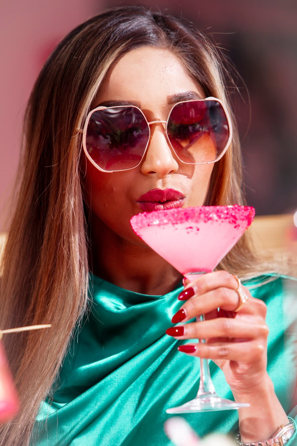 A vivid pink cocktail catching the golden-hour light