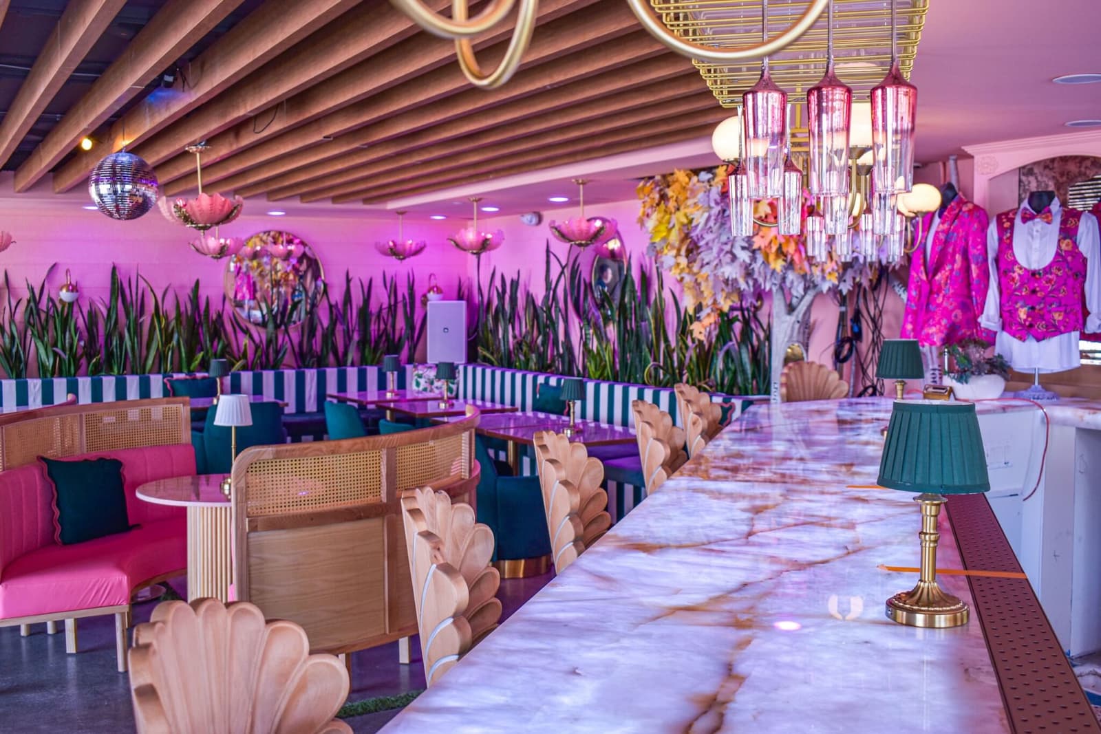 The marble bar under disco balls and a wall of painted blooms at Nigel's