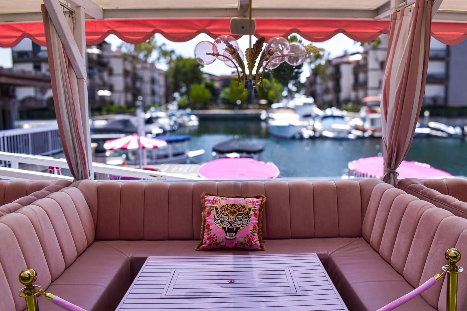A pink waterfront cabana booth set over the marina
