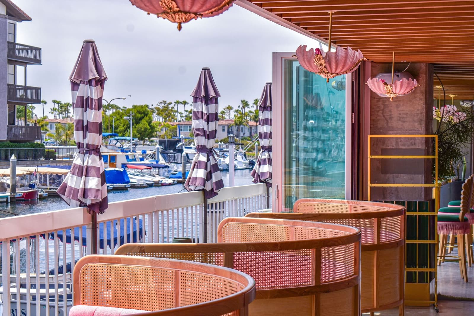 Candy-stripe umbrellas and cane chairs on the marina patio